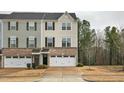 Townhome with a brick and siding exterior, a two-car garage, and a well-maintained lawn at 240 Amber Acorn Ave, Raleigh, NC 27603