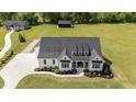 Aerial view of a stunning farmhouse highlighting its roofline and landscaped front yard at 2408 Eddie Howard Rd, Willow Springs, NC 27592