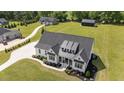 Aerial view of a modern farmhouse with black roof, landscaped front yard and long driveway at 2408 Eddie Howard Rd, Willow Springs, NC 27592