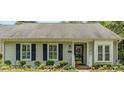 Close-up of a charming home's front entrance with a decorative door, flower beds, and manicured bushes at 2617 Cottage Cir, Raleigh, NC 27613