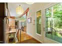 Bright entryway featuring hardwood floors and modern lighting, flowing into a kitchen with a breakfast bar at 2713 Mcdowell Rd, Durham, NC 27705