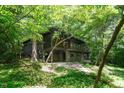 Modern home with floor-to-ceiling windows surrounded by lush greenery, offering a private, wooded view at 2713 Mcdowell Rd, Durham, NC 27705