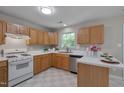 Well-lit kitchen with wood cabinets, white countertops, stainless steel appliances, and checkered floors at 314 Virens Dr, Cary, NC 27511