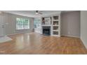 Bright living room featuring hardwood floors, a fireplace, and large windows offering plenty of natural light at 314 Virens Dr, Cary, NC 27511