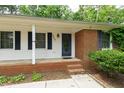 Inviting front entrance with brick steps, a decorative blue door, and white siding with black shutters at 3517 Morningside Dr, Raleigh, NC 27607