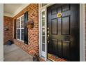 Elegant black front door with decorative hardware, sidelight, and seasonal decorations creating a warm entrance at 3619 Lion Ridge Ct, Raleigh, NC 27612