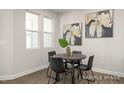 Cozy dining area with wood-look flooring features a modern round table and a beautiful art display at 3920 Well Fleet Dr, Fuquay Varina, NC 27526