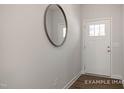 Clean entryway featuring a white door, modern mirror, and wood-look flooring, creating a welcoming first impression at 3924 Well Fleet Dr, Fuquay Varina, NC 27526
