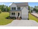 Charming two-story home with a welcoming front porch, gravel drive, and well manicured lawn at 412 Carr Store Rd, Cedar Grove, NC 27231