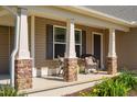 Inviting front porch with rocking chairs, stone pillars, and a dark front door at 50 Viajar Way, Smithfield, NC 27577