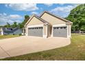 Three-car garage with a large concrete driveway and partial lawn at 50 Viajar Way, Smithfield, NC 27577