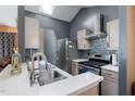 Well-lit kitchen with stainless steel appliances, quartz countertop, stylish backsplash, and modern range hood at 505 Stratton Way, Durham, NC 27704