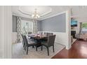 Formal dining room with elegant lighting, large window, and decorative chair rail detail at 5412 Emerald Spring Dr, Knightdale, NC 27545
