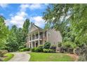 Two-story home features a grand columned porch, well-maintained lawn, and a mix of brick and siding exterior at 5521 Erinvale Ct, Holly Springs, NC 27540