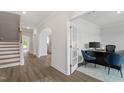 Bright hallway with hardwood floors, an archway, and a view into the office with french doors at 60 Bold Dr, Youngsville, NC 27596