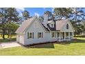 Stylish home featuring a side-entry garage, light blue siding, and a well-manicured lawn at 620 Richardson Rd, Zebulon, NC 27597