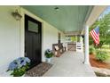 Inviting front porch with comfortable seating, blue hydrangeas and a welcoming bench at 6447 Beulah Church Rd, Liberty, NC 27298
