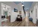 Hallway with a blue ceiling, shiplap walls, and hardwood floors with view to formal living room at 6447 Beulah Church Rd, Liberty, NC 27298
