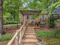 Inviting backyard featuring a rustic pergola and quaint seating area, perfect for relaxation at 6925 Valley Lake Dr, Raleigh, NC 27612