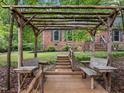 Backyard featuring a wooden pergola with built-in benches and serene outdoor space at 6925 Valley Lake Dr, Raleigh, NC 27612