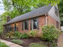 Side exterior showcasing brick facade with dark shutters, lush landscaping, and a welcoming entrance at 6925 Valley Lake Dr, Raleigh, NC 27612