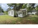 Rear view of a small, dated house with visible wear, complemented by lush green grass at 752 Nashville Rd, Rocky Mount, NC 27803
