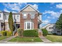 Charming two-story townhome with brick facade, manicured lawn, and inviting front steps at 100 Stratford Lakes # 130, Durham, NC 27713