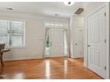 Sun-lit entryway showcasing hardwood floors and a white front door at 105 Old Barn Way, Wendell, NC 27591