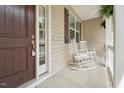 Inviting front porch featuring rocking chairs and a neutral exterior at 105 Old Barn Way, Wendell, NC 27591
