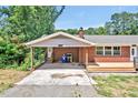 A detailed shot of the carport showing the red brick and adjacent porch at 112 S Joyland St, Durham, NC 27703