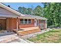 Close-up of a brick home showing the front porch, carport, and fresh landscaping at 112 S Joyland St, Durham, NC 27703