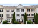 Attractive townhome exterior with symmetrical landscaping, dark shutters, and a charming covered front porch at 1120 Renewal Pl # 111, Raleigh, NC 27603