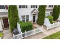 A charming front entrance with a white picket fence, manicured greenery, and an inviting front door at 1120 Renewal Pl # 111, Raleigh, NC 27603