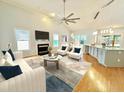 Bright, open living room with fireplace, large ceiling fan, and view to the adjacent eat-in kitchen at 121 Chimney Rise Dr, Cary, NC 27511