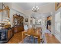 Elegant dining room with hardwood floors, chandelier, and decorative china cabinet at 12221 Orchardgrass Ln, Raleigh, NC 27614