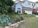 Beautiful two-story home with brick and siding exterior complemented by lush landscaping at 12221 Orchardgrass Ln, Raleigh, NC 27614