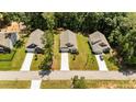 Aerial view of three modern homes with manicured lawns and long driveways in a suburban neighborhood with mature trees at 159 Clear Water Rd, Louisburg, NC 27549