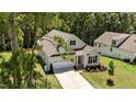 An aerial view of a well-maintained single-Gathering home with an attached two-car garage, manicured lawns and gardens at 159 Clear Water Rd, Louisburg, NC 27549