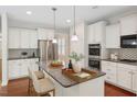Bright, modern kitchen featuring white cabinets, stainless steel appliances, and granite countertops at 1600 Drift Falls Ln, Wendell, NC 27591