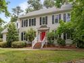 Charming two-story home with black shutters and a red front door at 18 Acornridge Ct, Durham, NC 27707