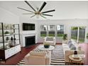 Staged living room featuring a fireplace, a ceiling fan and three windows for natural light at 2072 Tanners Mill Dr, Durham, NC 27703