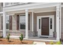 Inviting front entrance with a dark wood door, white trim, and partial brick facade at 2178 Pink Peony Circle Lot 167 Cir, Durham, NC 27703