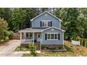 Charming home showcases a classic facade, complemented by manicured landscaping and a quaint covered porch at 225 Sacred Fire Rd, Louisburg, NC 27549