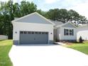 View of a single-story home with a gray two-car garage, light-blue shutters, and a well-manicured lawn at 235 Eason Creek Way, Clayton, NC 27527