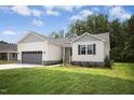 Attractive single-story house showcasing light grey siding, a well kept lawn, and a grey garage at 235 Eason Creek Way, Clayton, NC 27527