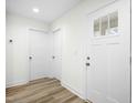Bright foyer with white walls, wood-look flooring, and a front door with glass panels at 235 Eason Creek Way, Clayton, NC 27527
