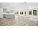 Open-concept living space featuring wood-look floors and natural light through bright windows at 235 Eason Creek Way, Clayton, NC 27527