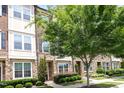 Townhome featuring a brick facade, stone accents, and lush landscaping at 3109 Stockdale Dr, Raleigh, NC 27609