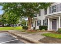 Beautifully landscaped townhome exterior with lush greenery, inviting entrance, and sidewalk at 3141 Rapid Falls Rd, Cary, NC 27519