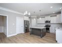 Spacious kitchen with white cabinets, stainless steel appliances, large island, and wood-look flooring at 453 Granite Saddle Dr, Rolesville, NC 27571